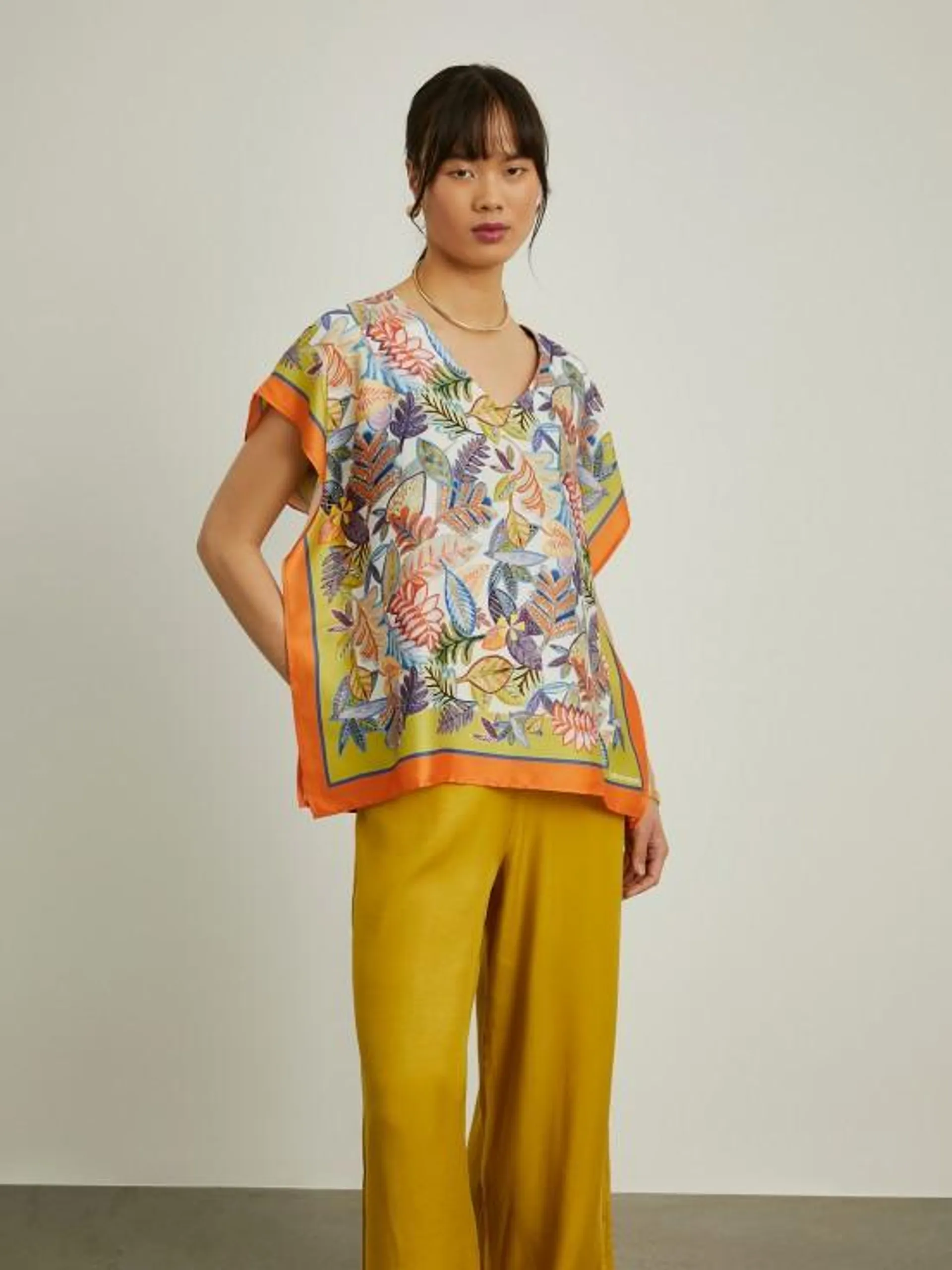 Blusa estilo poncho con estampado tropical.