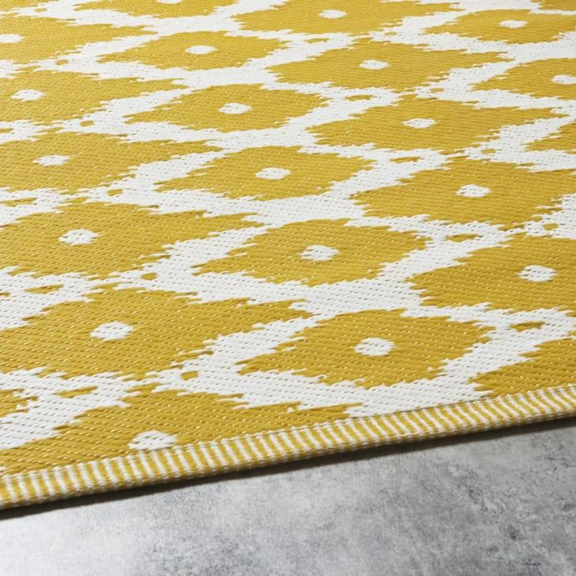 Alfombra reversible de polipropileno amarillo con motivos gráficos blancos 180x270