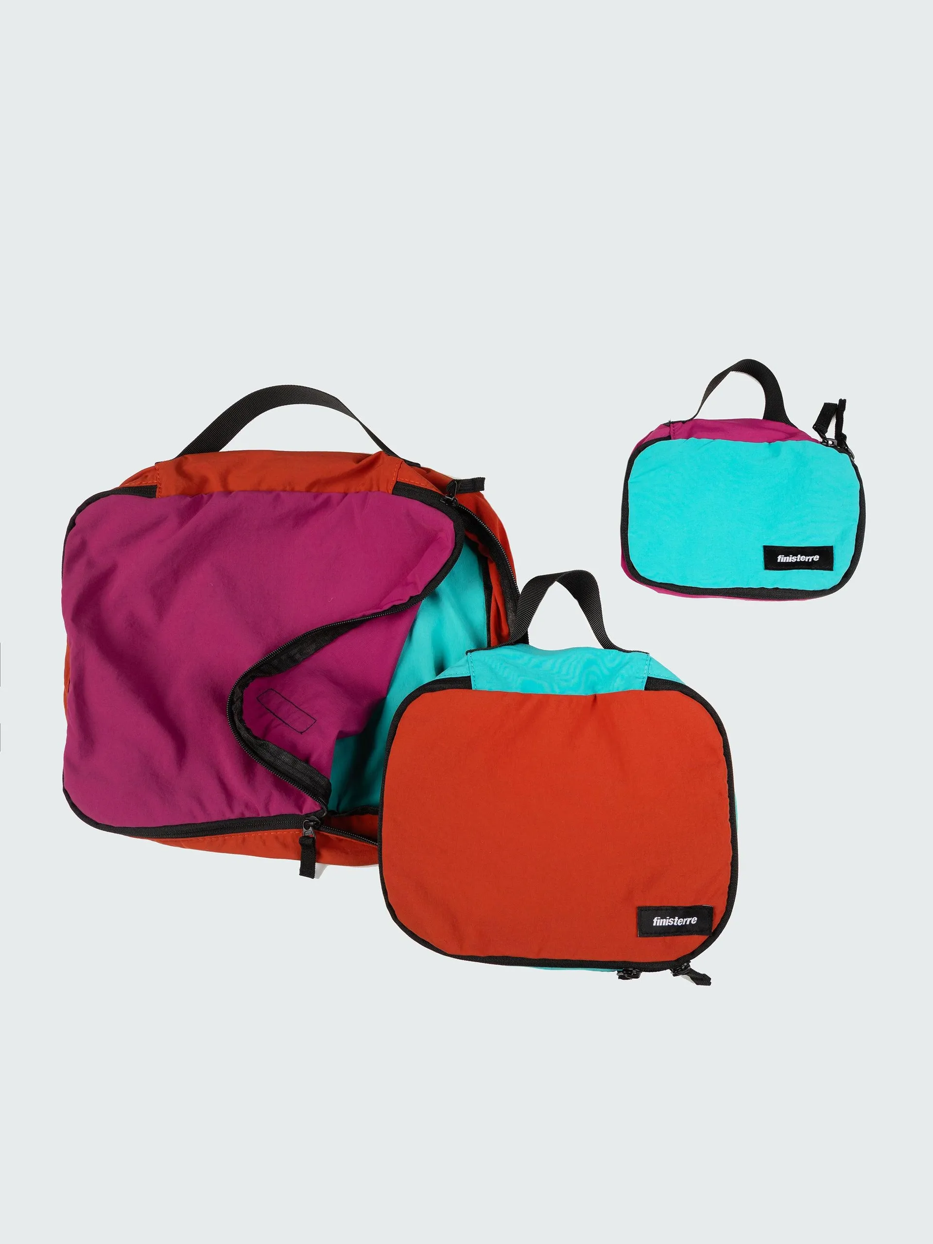 Recycled packing cubes in our mulberry, brick red and aqua